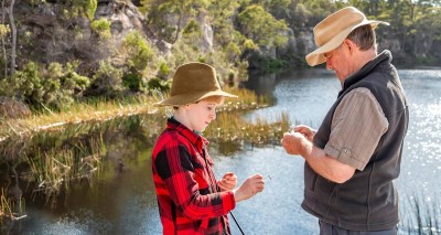 Father and son fishing on the lake and baiting a hook.